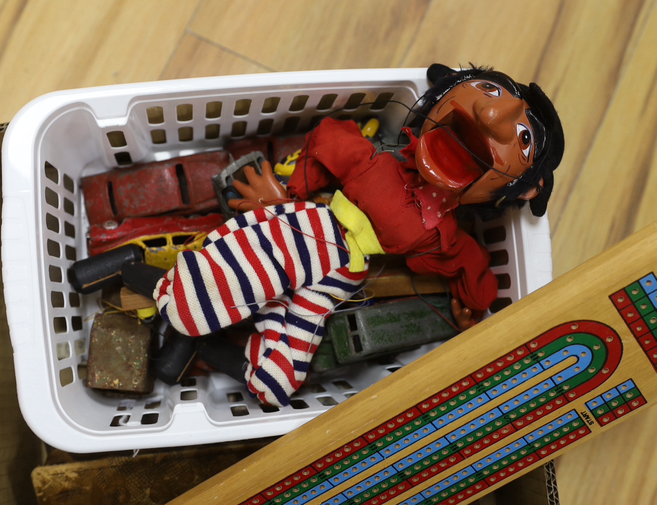 A quantity of toys including Dinky, Pelham puppet and cribbage board, the largest 38cm wide